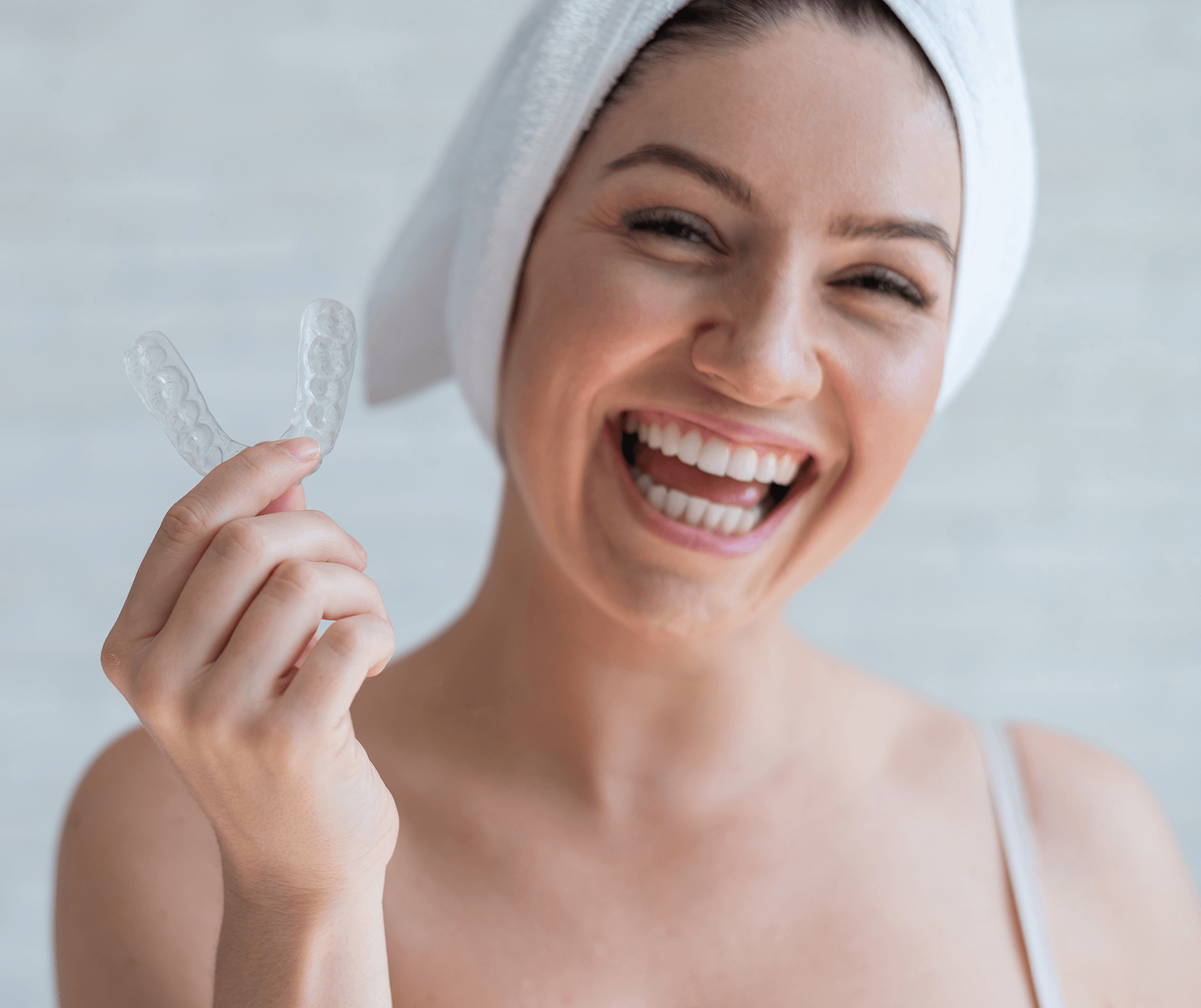Woman smiling holding aligner tray