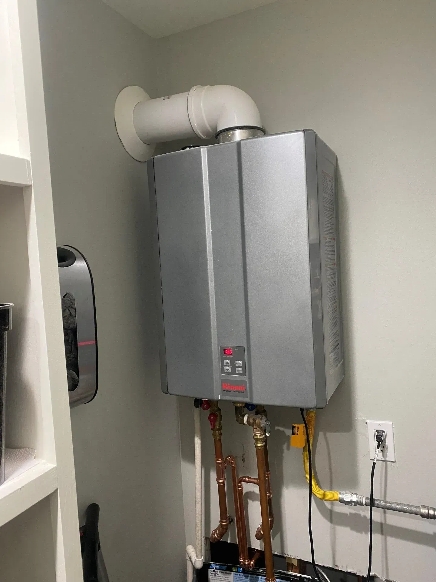 A water heater is hanging on the wall in a room