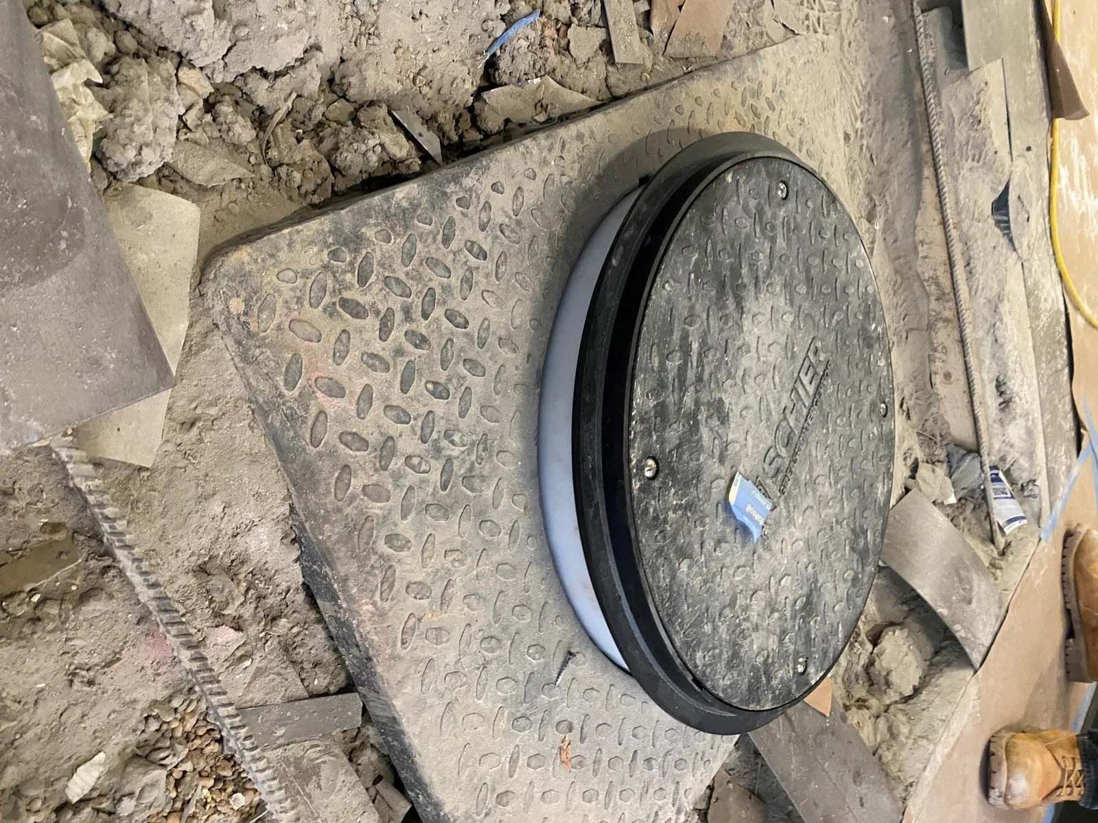 A septic cover is sitting on top of a concrete surface