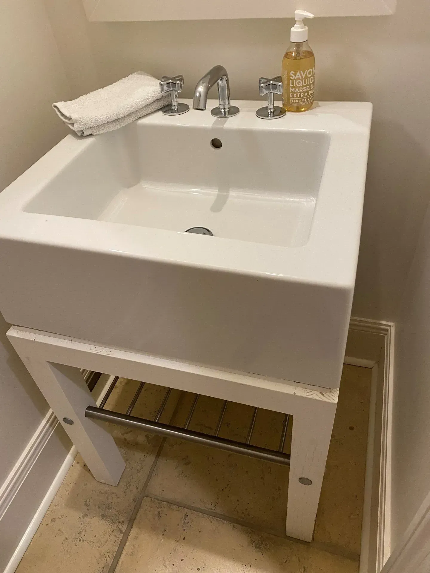 A bathroom sink with a soap dispenser and a towel on top of it