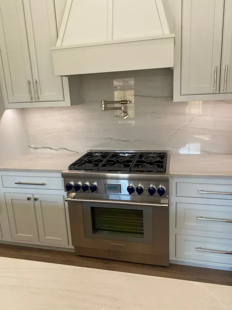 A kitchen with stainless steel appliances and white cabinets