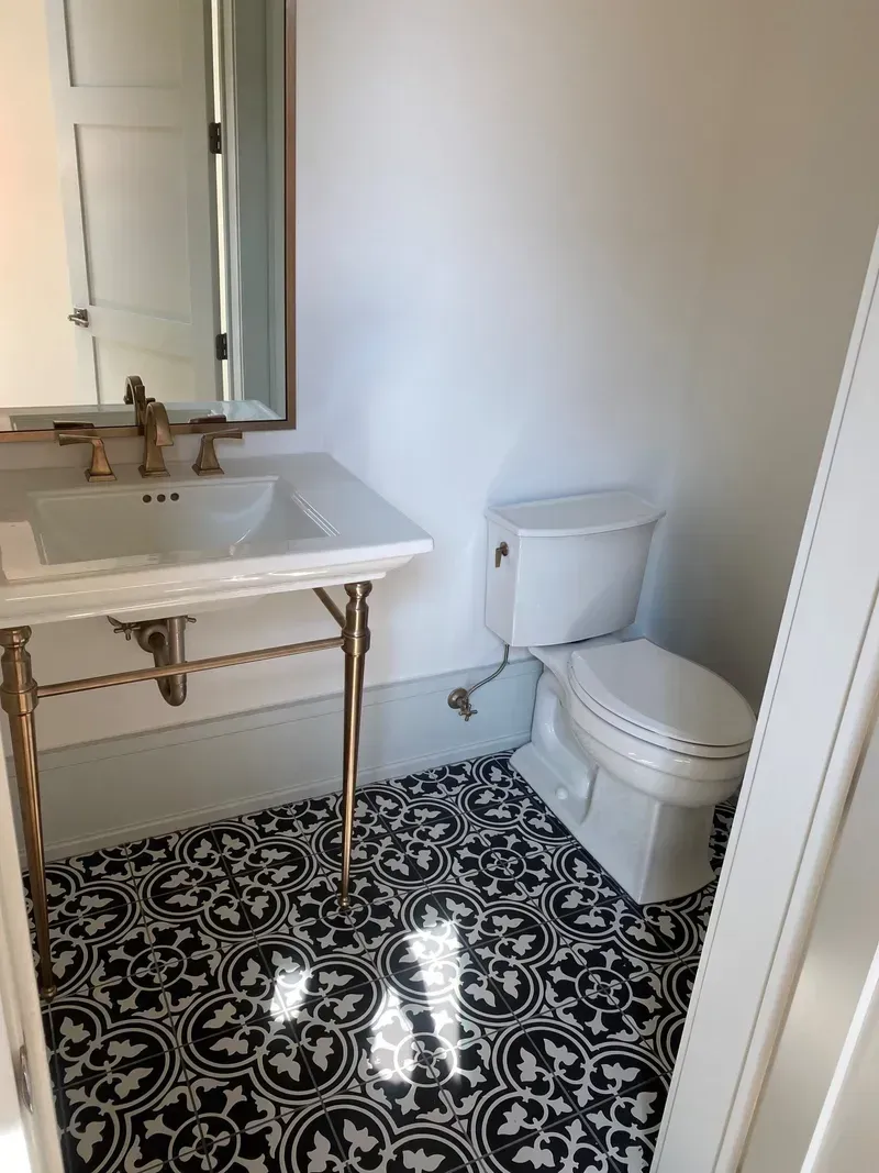 A bathroom with a sink, toilet and mirror