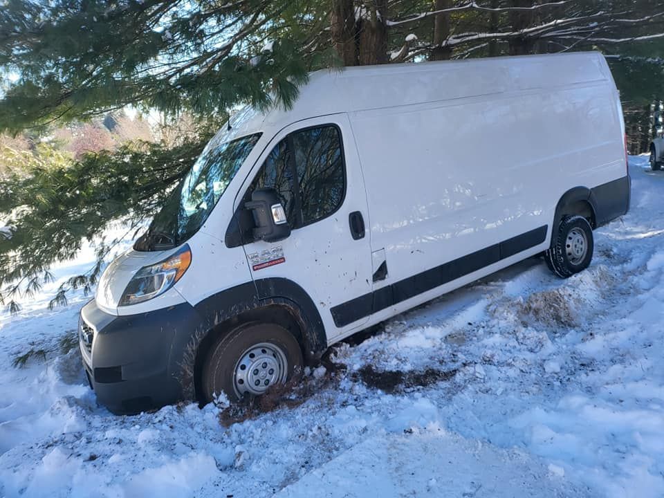 A white van is stuck in the snow.
