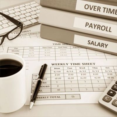 A cup of coffee sits on top of a weekly time sheet