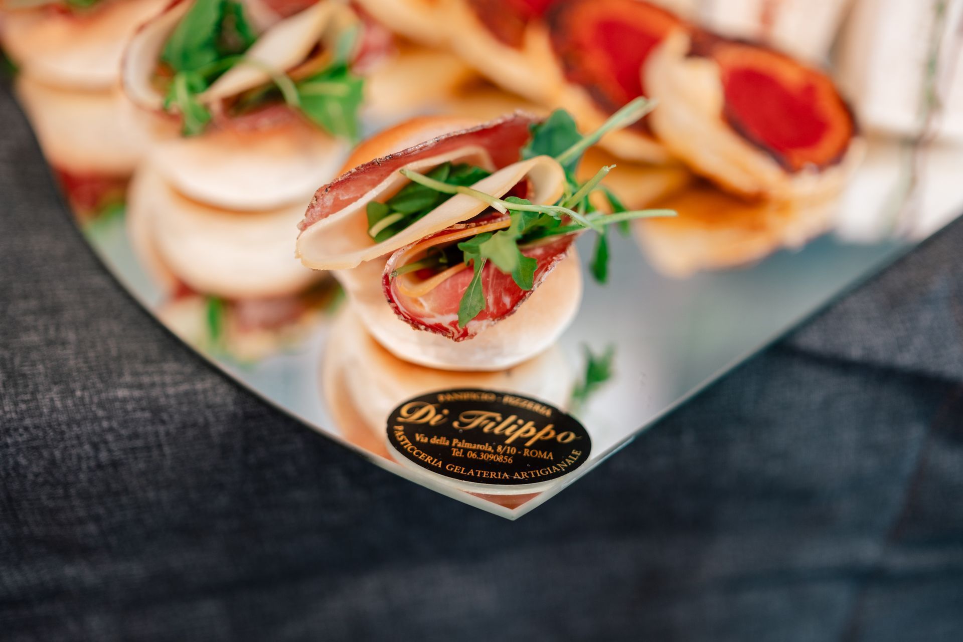 Mini coppette di antipasto con gamberetti, erbe aromatiche e pomodoro su un vassoio d'argento durante un evento con catering.