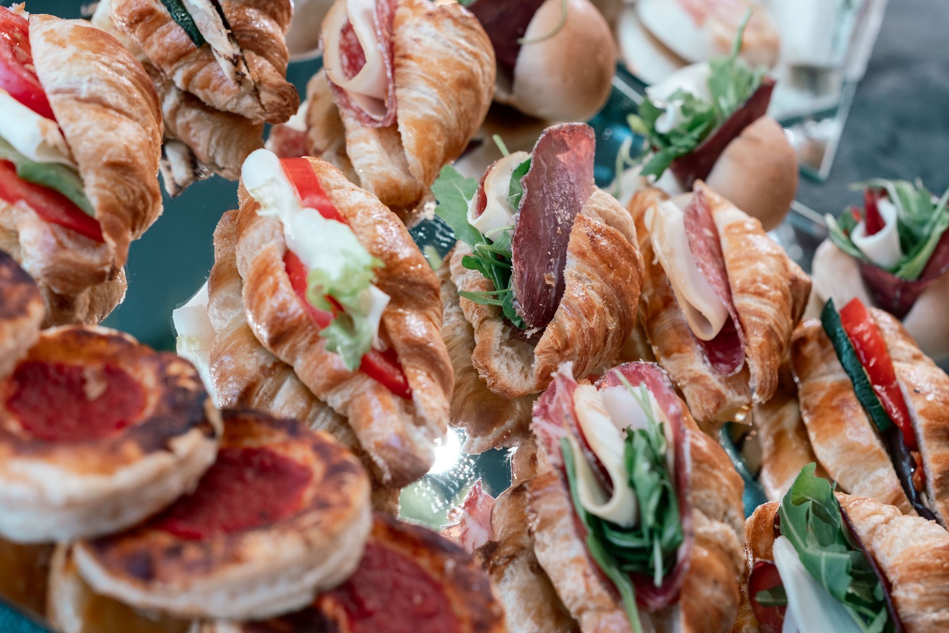 Assortimento di croissant farciti e pasticcini con verdure e carne su un vassoio