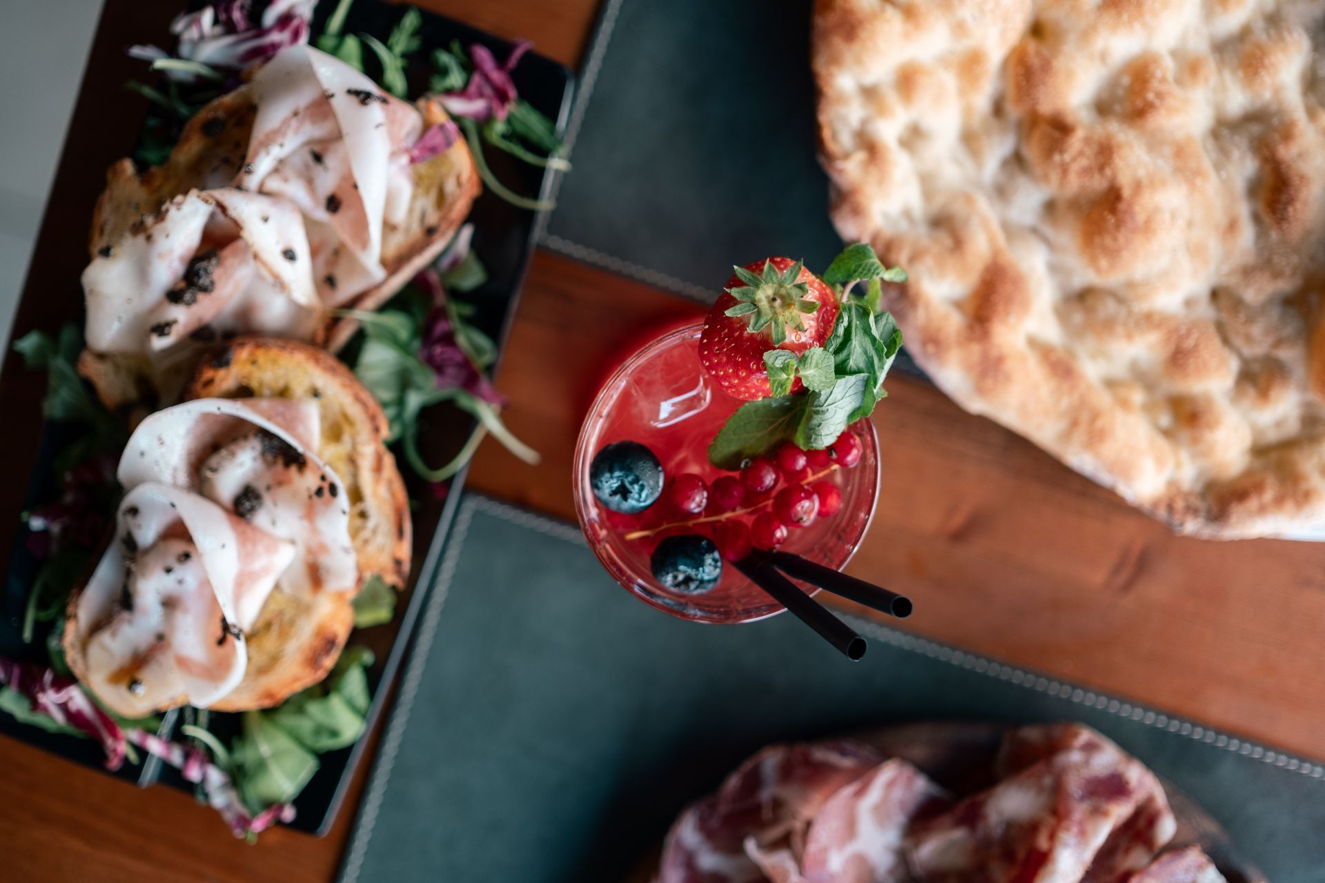 Un ricco buffet di dessert e bevande colorate, tra cui un cocktail ai frutti rossi e pasticcini impiattati.