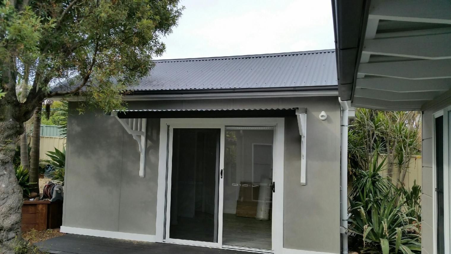 A Small Gray Shed With a Corrugated Metal Roof — Cessnock Glass in Cessnock, NSW