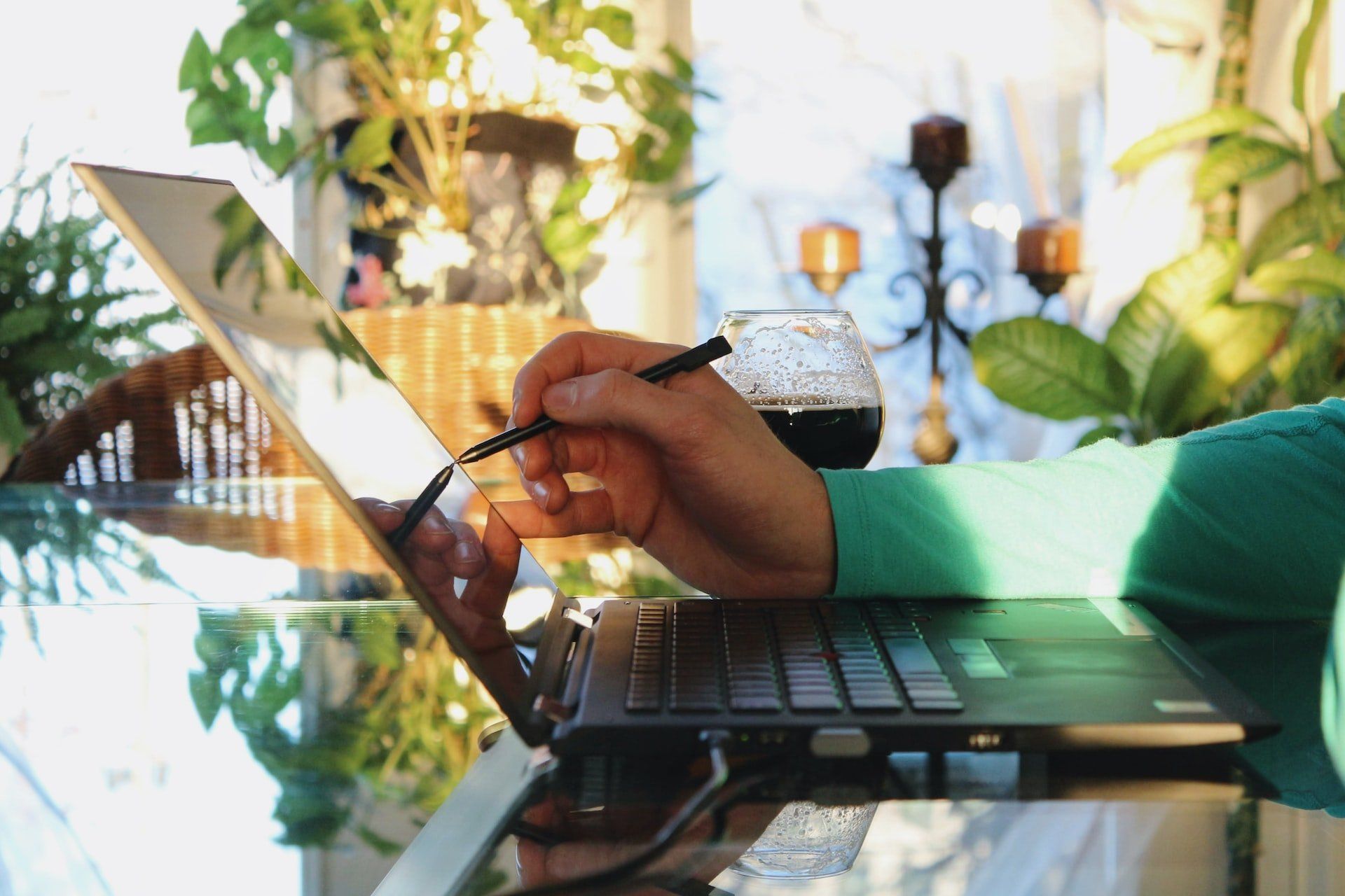 Image of a laptop and someone using a pen to write on the screen