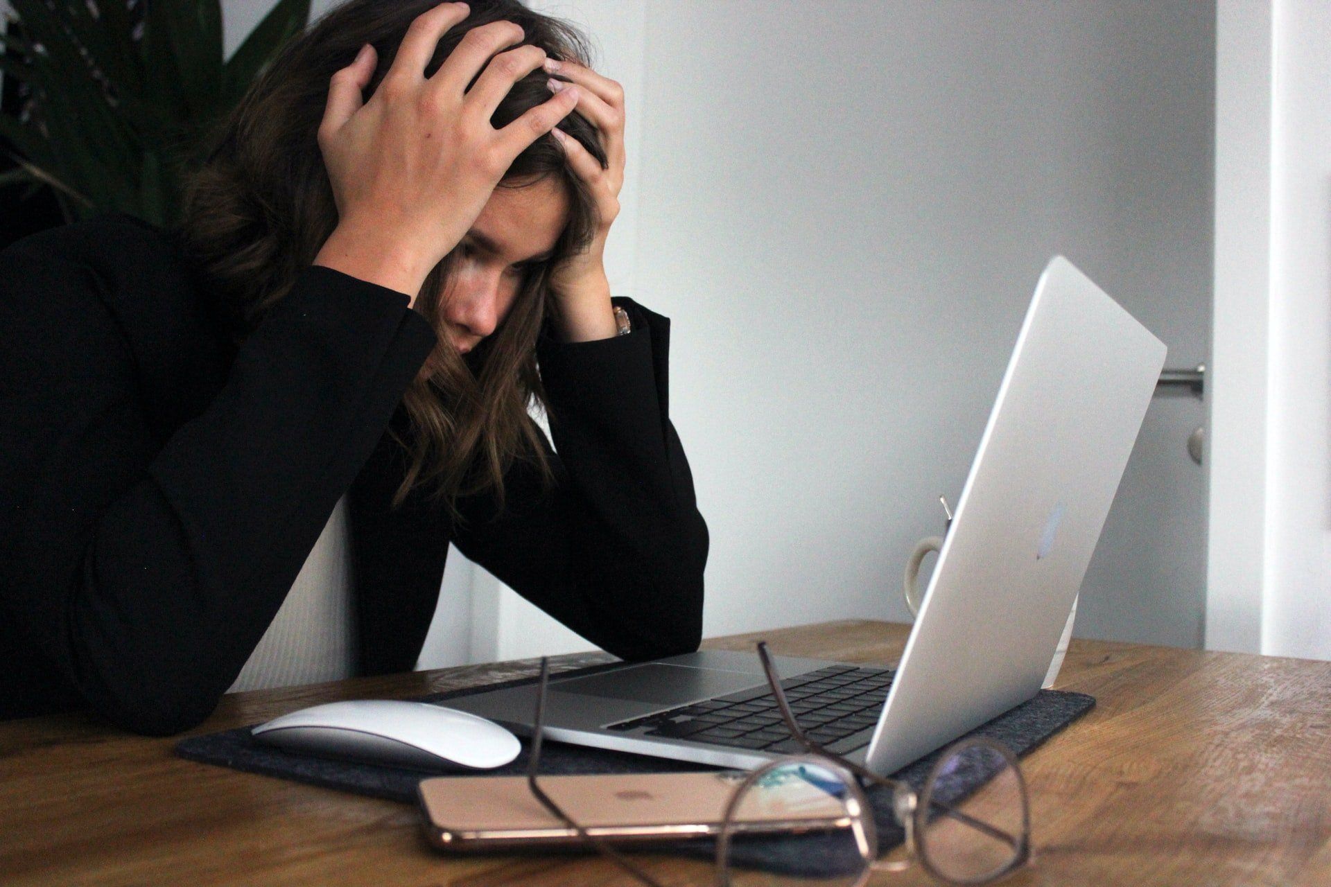Image of a person looking frustrated at a laptop that's running out of power