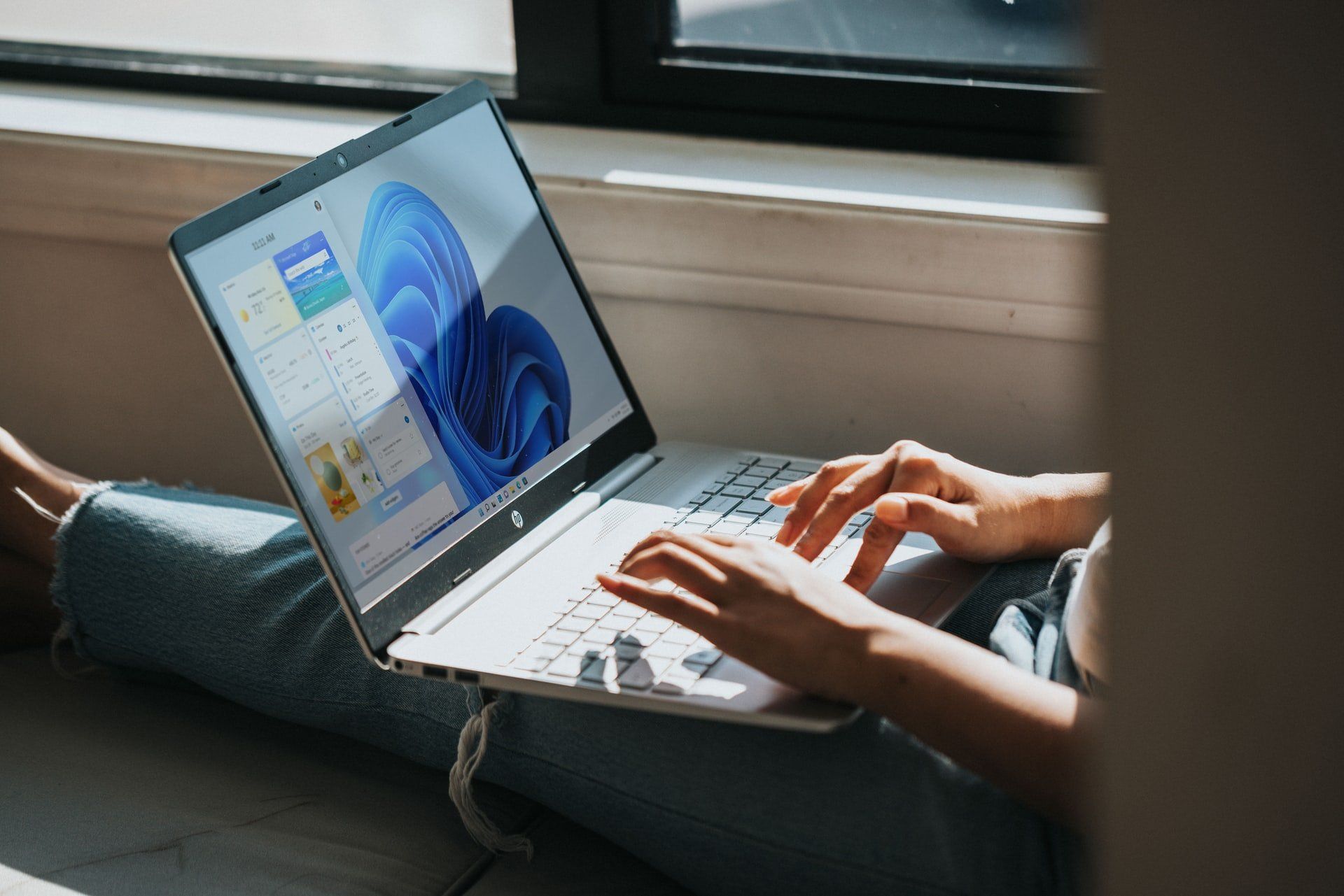 Image of a person with a laptop on their lap, running Windows 11