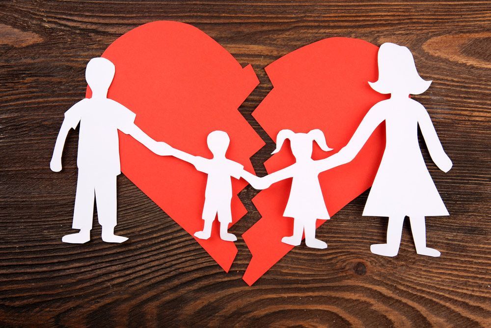 Paper cutout silhouette of a family split apart on a paper heart — Family Law Solicitors in Muswellbrook NSW