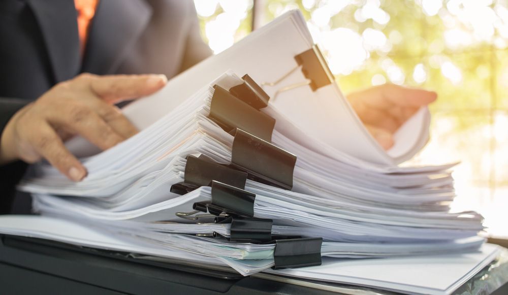 Lawyer working in Stacks of paper files for searching information — Solicitors in Muswellbrook NSW