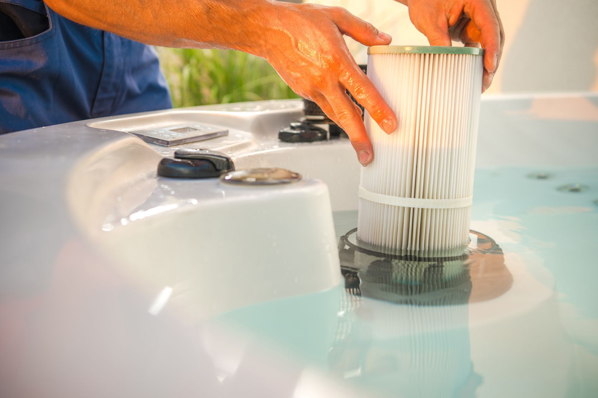 A technician is removing a water filter and performing scheduled garden spa maintenance.