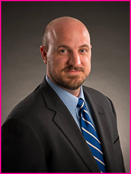 A man in a suit and tie is smiling for the camera.