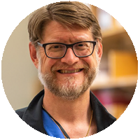 A man with glasses and a beard is smiling in a circle