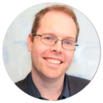 A man wearing glasses is smiling in a circle.