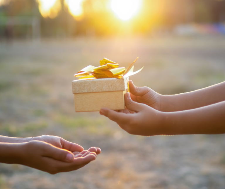 A person is giving a gift box to another person.