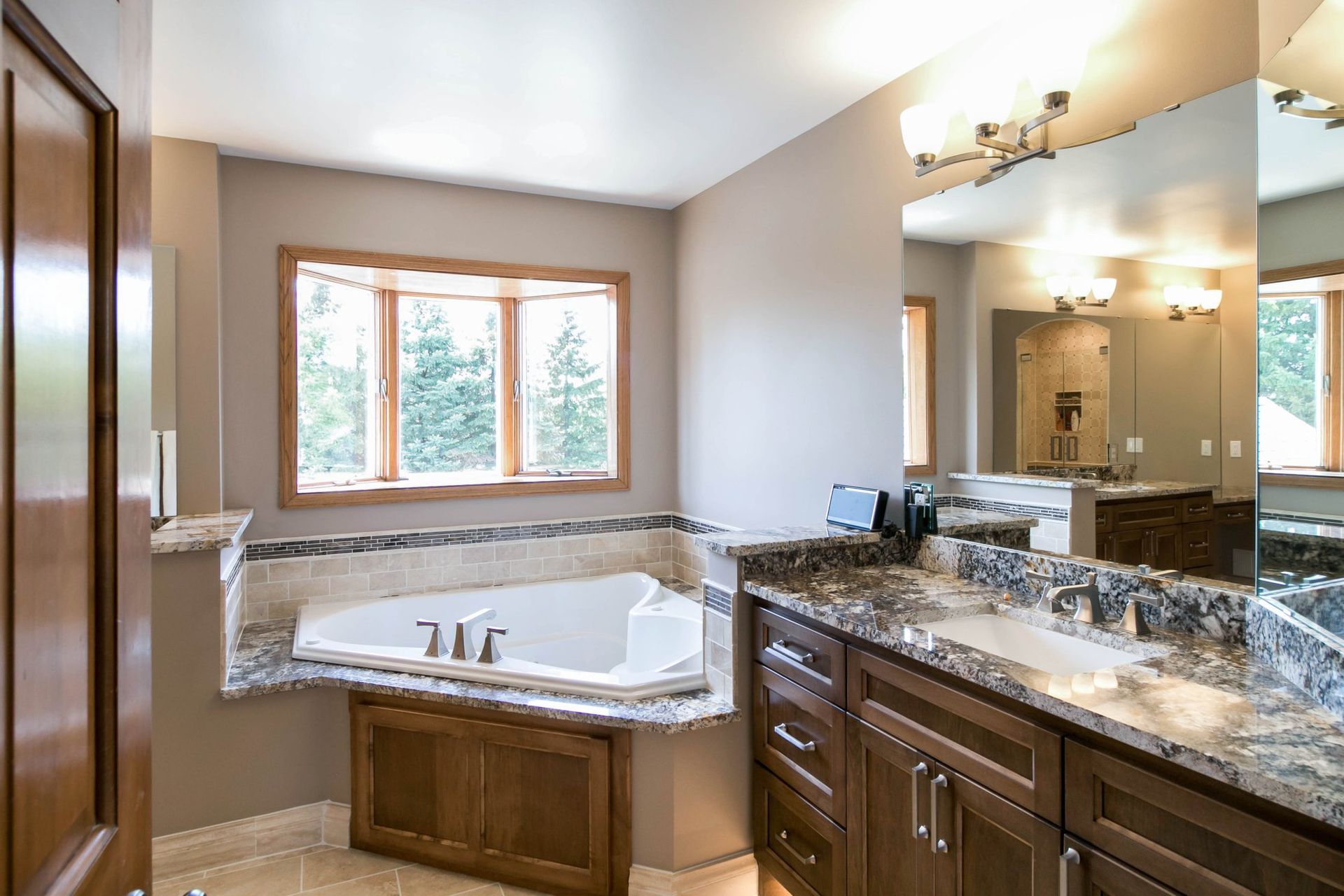 A bathroom with two sinks , a tub , and a mirror. A bathroom with two sinks , a tub , and a mirror.