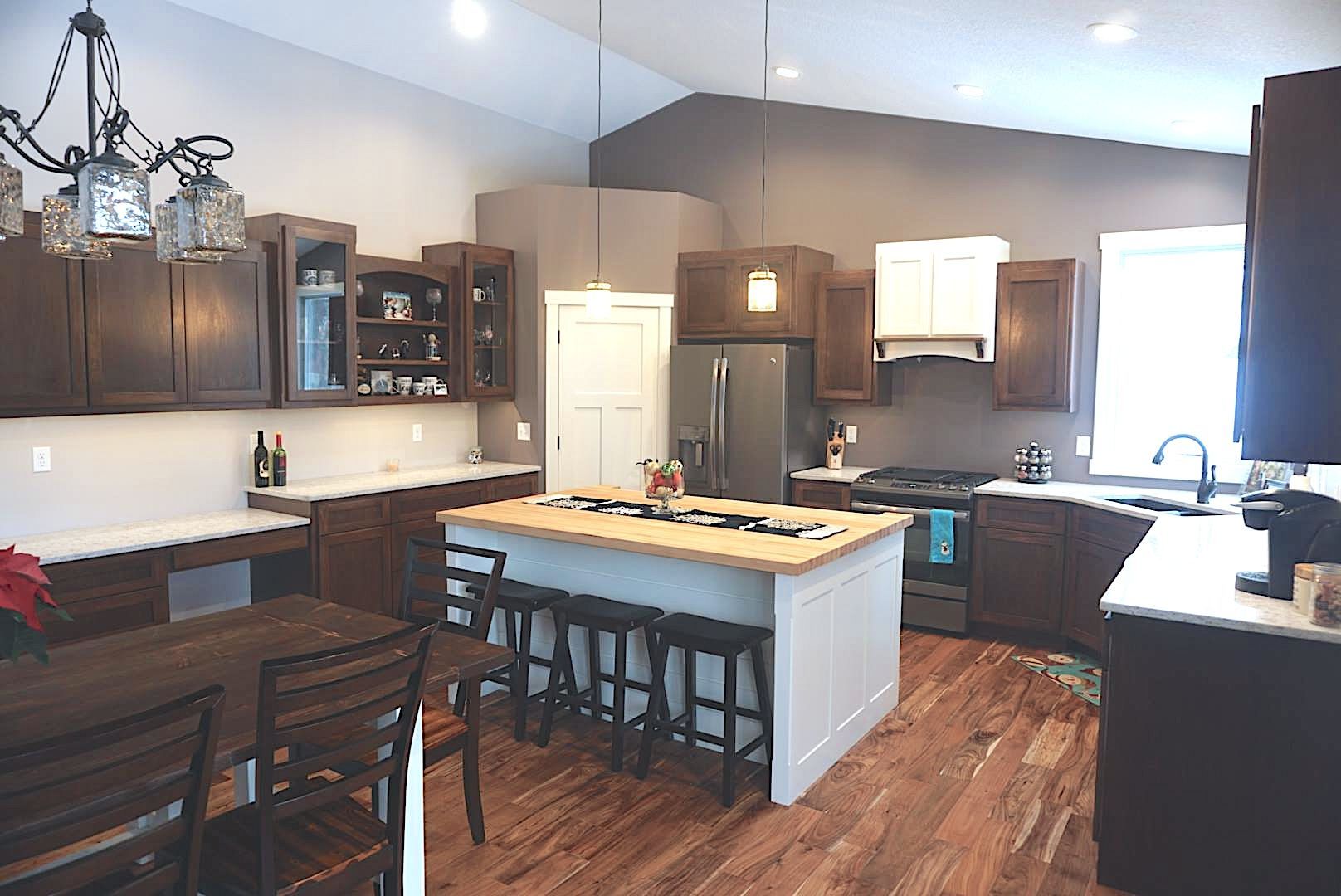 A kitchen with a large island in the middle and a table and chairs. A kitchen with a large island in the middle and a table and chairs.
