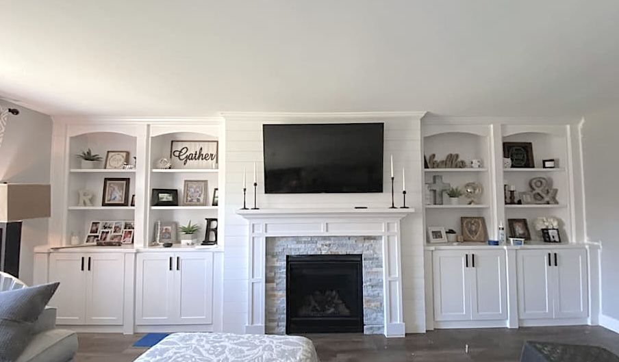 A living room with a fireplace , shelves , and a flat screen TV. A living room with a fireplace , shelves , and a flat screen TV.