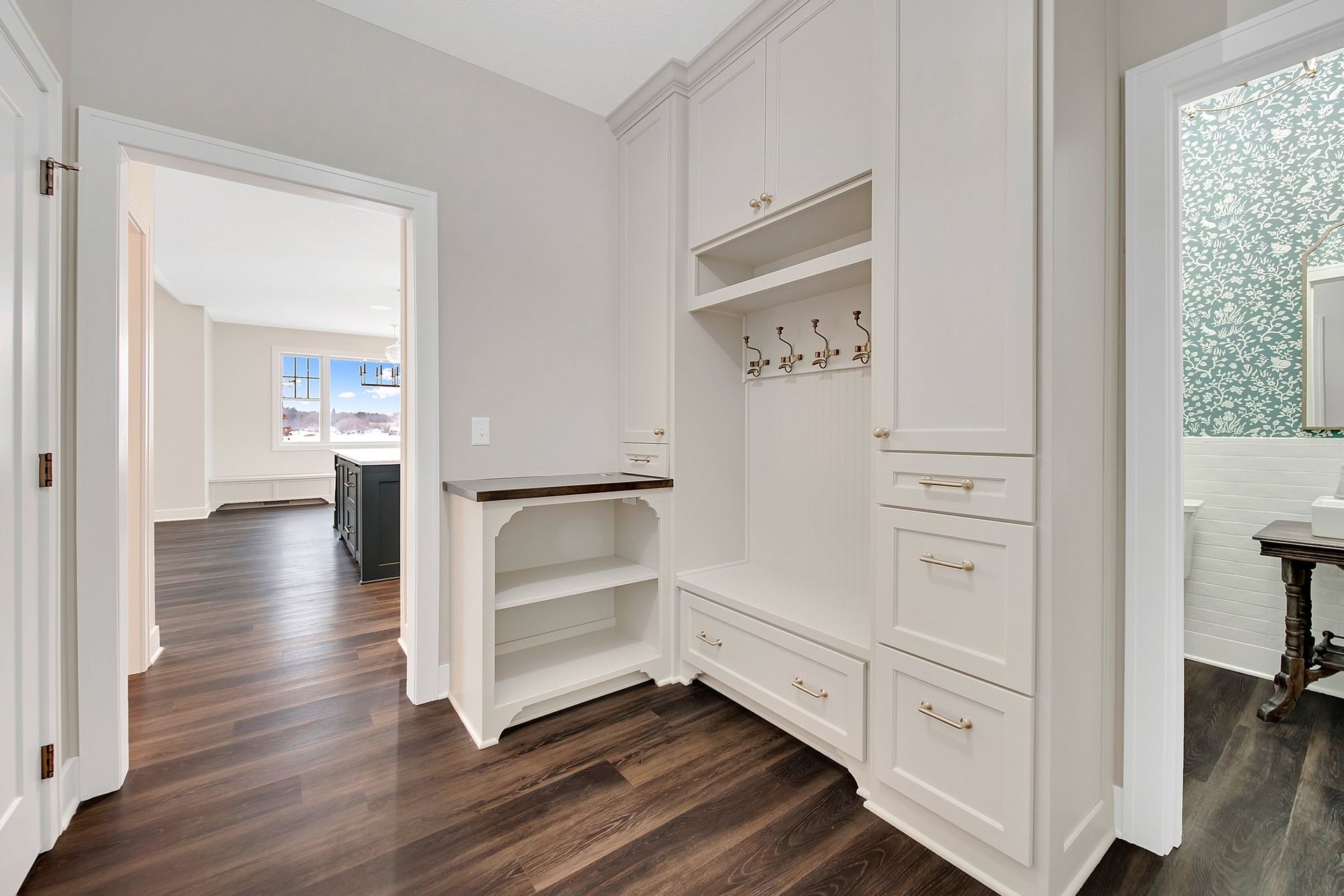 A hallway with hardwood floors and white cabinets A hallway with hardwood floors and white cabinets