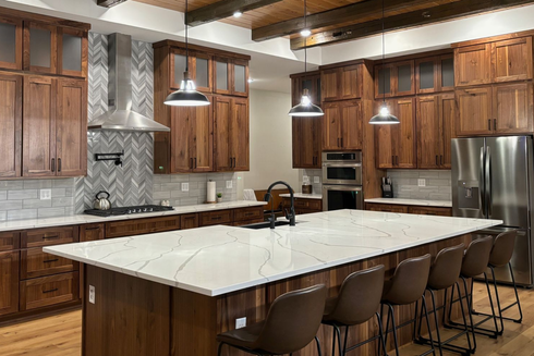 Walnut cabinetry by Twin River Cabinets featuring rich wood tones, an oversized island, and elevated kitchen details.