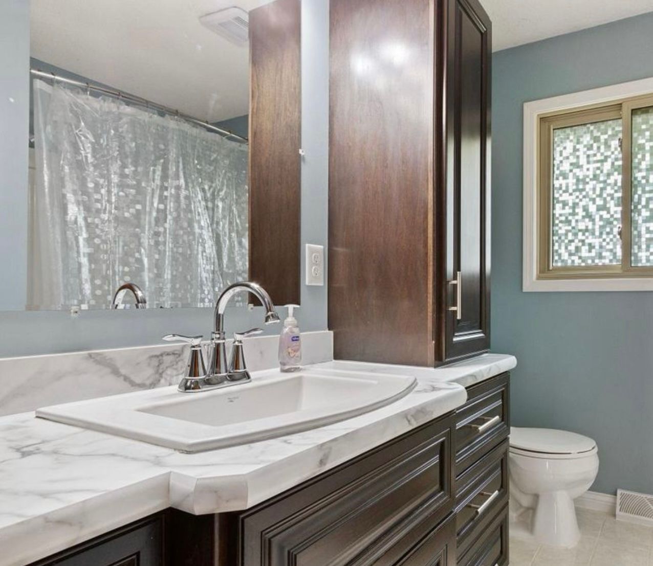 Dark wood bathroom vanity with custom drawer and tall cabinet storage in Blaine, MN
