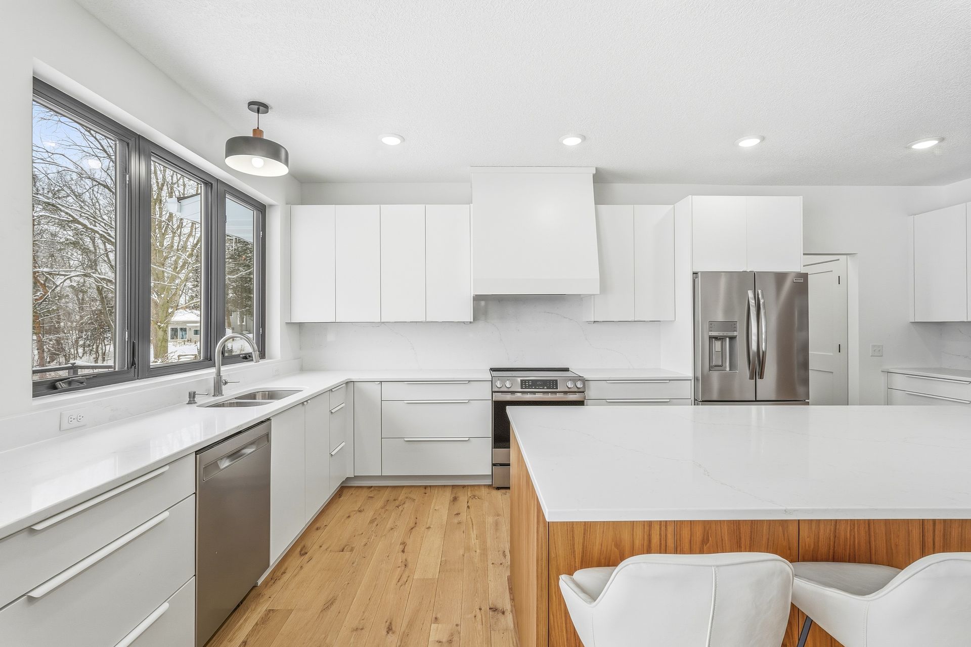 Modern white Signature Collection kitchen cabinets with walnut island and clean slab-style doors in Centerville, Minnesota.
