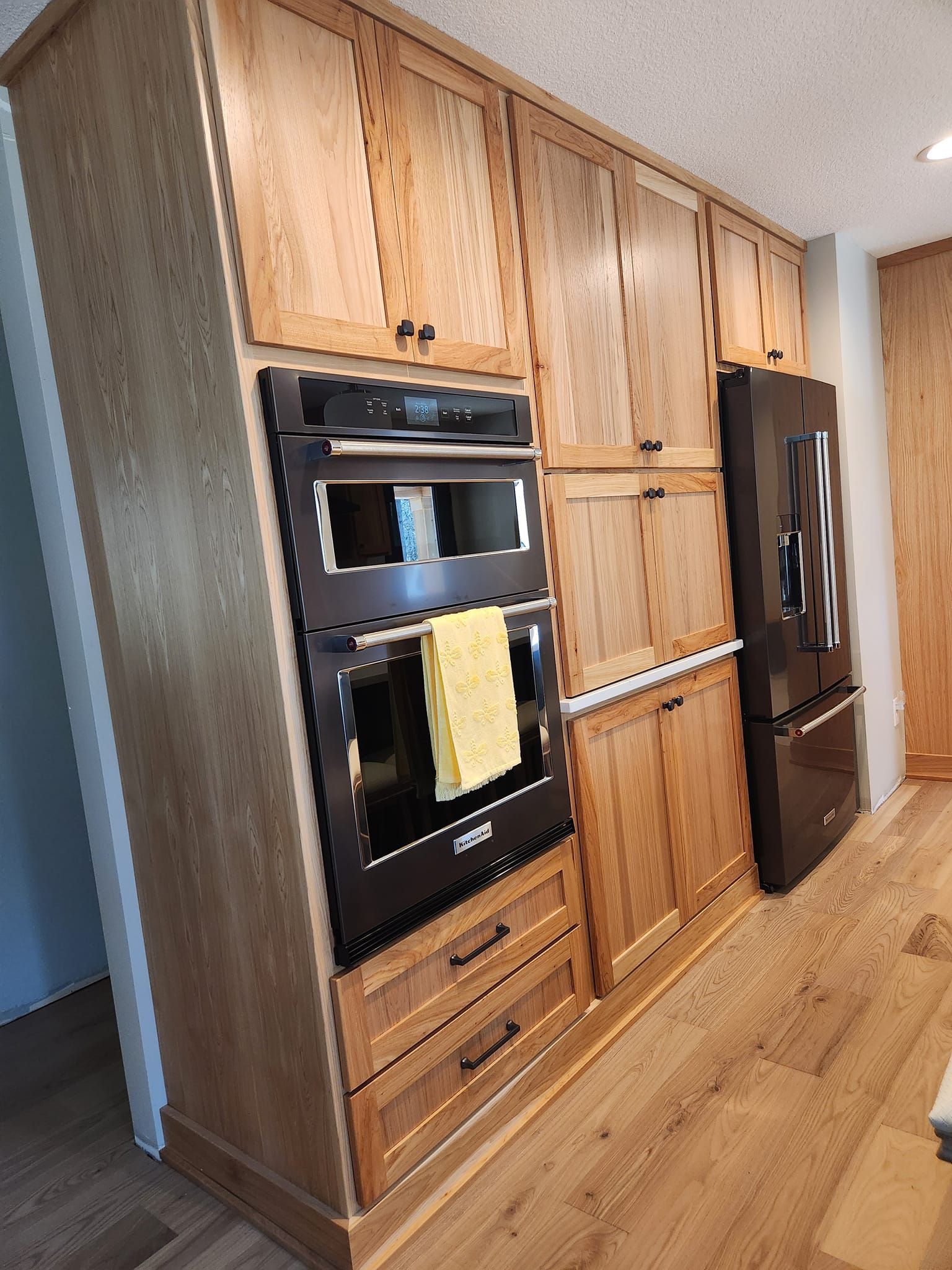Floor-to-ceiling custom wood kitchen cabinetry with built-in storage and drawers