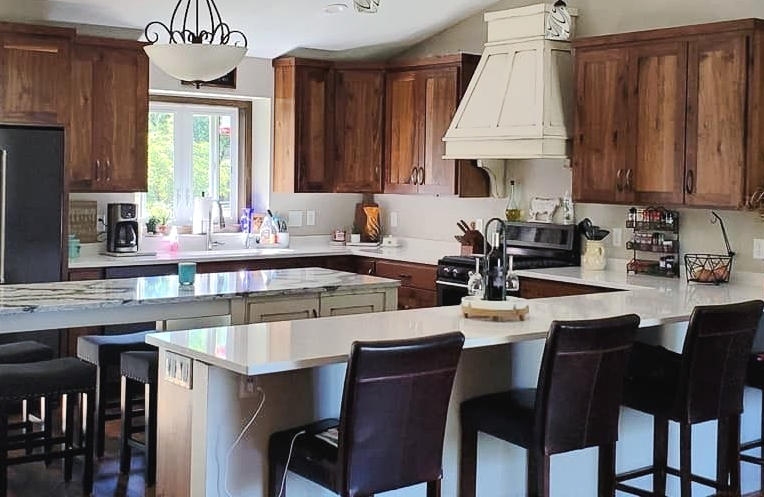 Natural wood Signature Collection kitchen with contrasting island and peninsula seating in East Bethel, Minnesota.