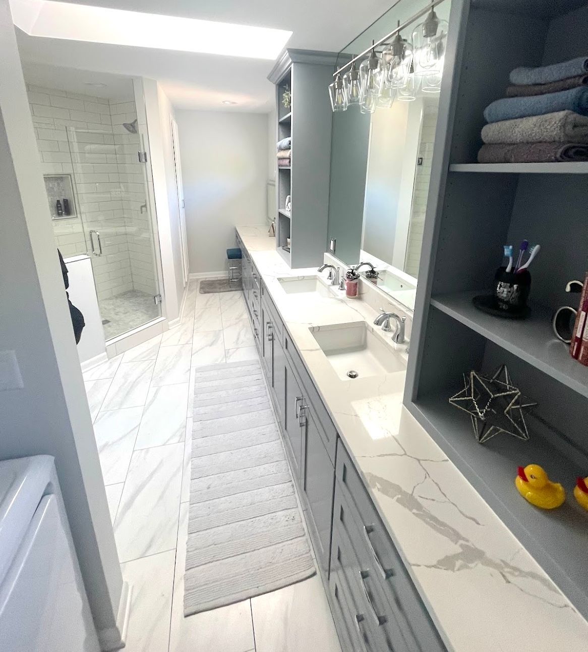 Custom gray double bathroom vanity with built-in shelving and extensive drawer storage
