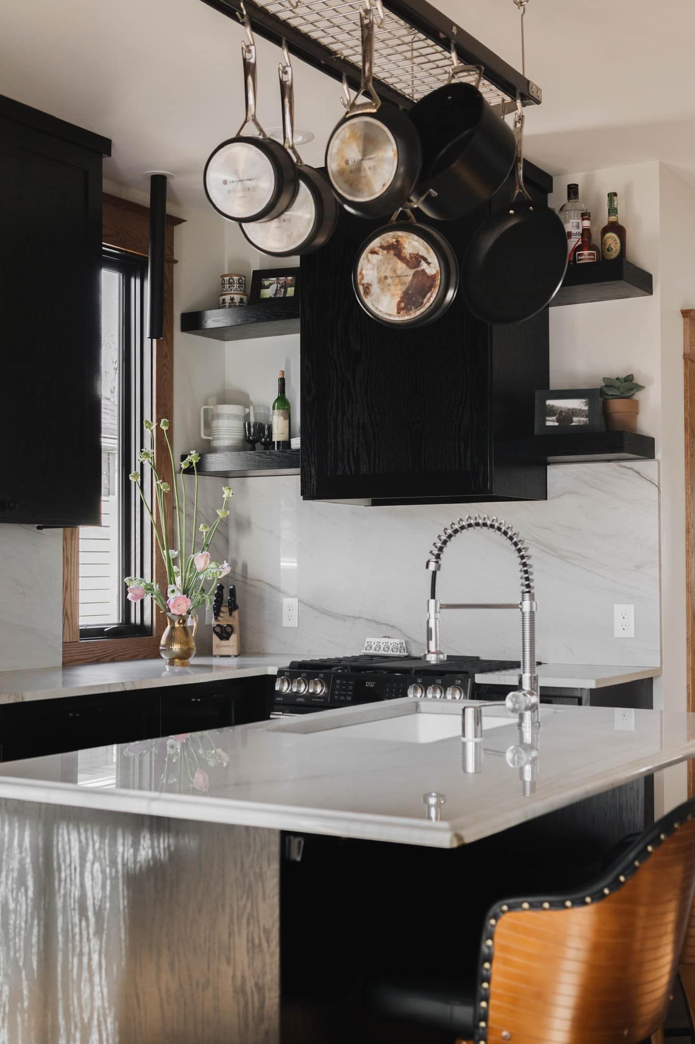 Custom black oak kitchen cabinetry with open shelving, white island, and hanging pot storage in Inver Grove Heights, Minnesota.