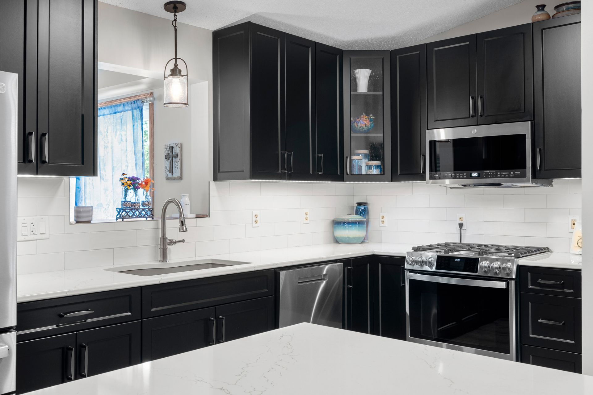 Black Casa Collection kitchen cabinets with white subway tile backsplash and stainless steel appliances in Lino Lakes, Minnesota.