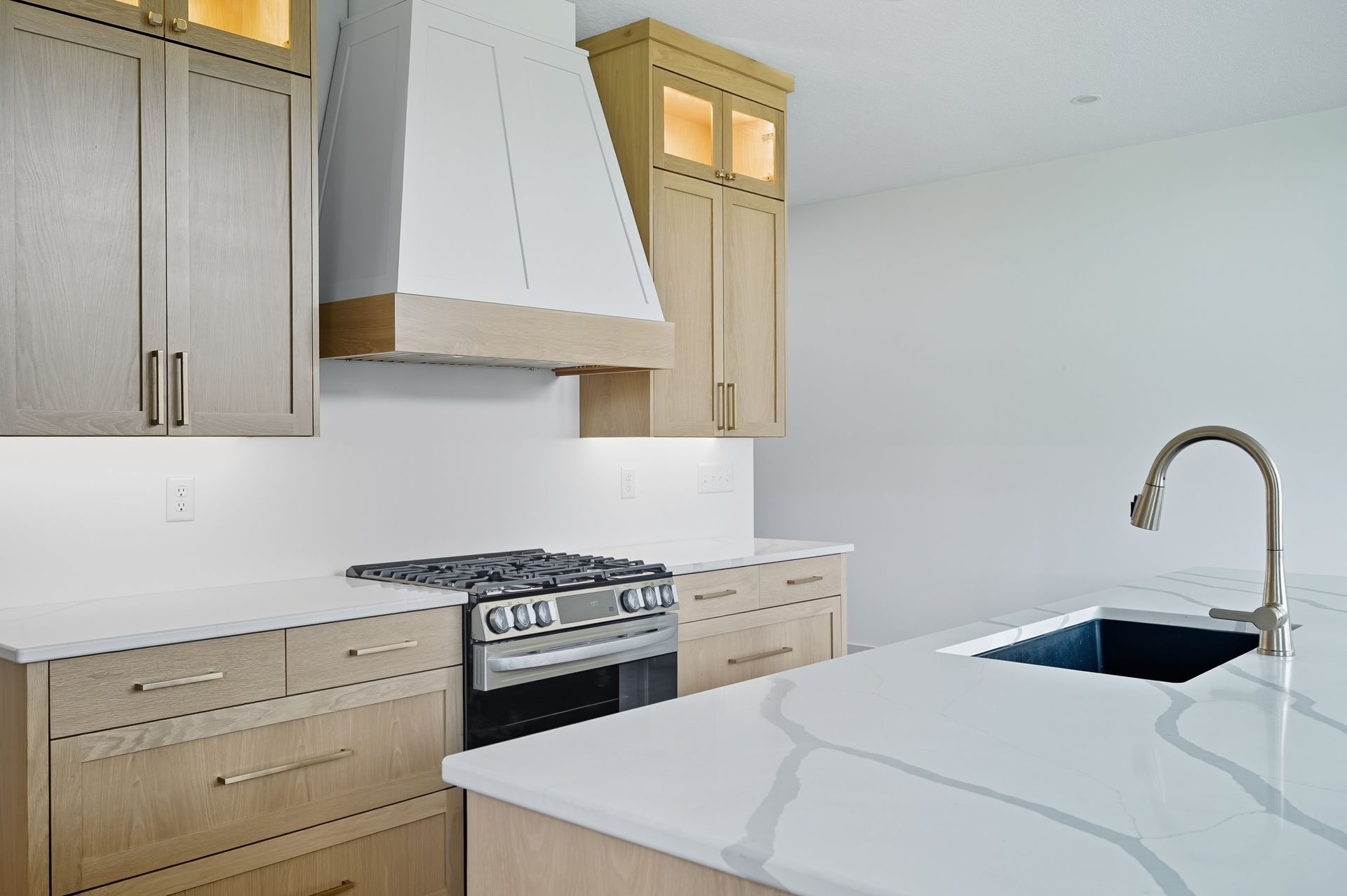 White oak Luxe Collection kitchen cabinets with floating shelves and natural wood grain in Oak Grove, Minnesota.
