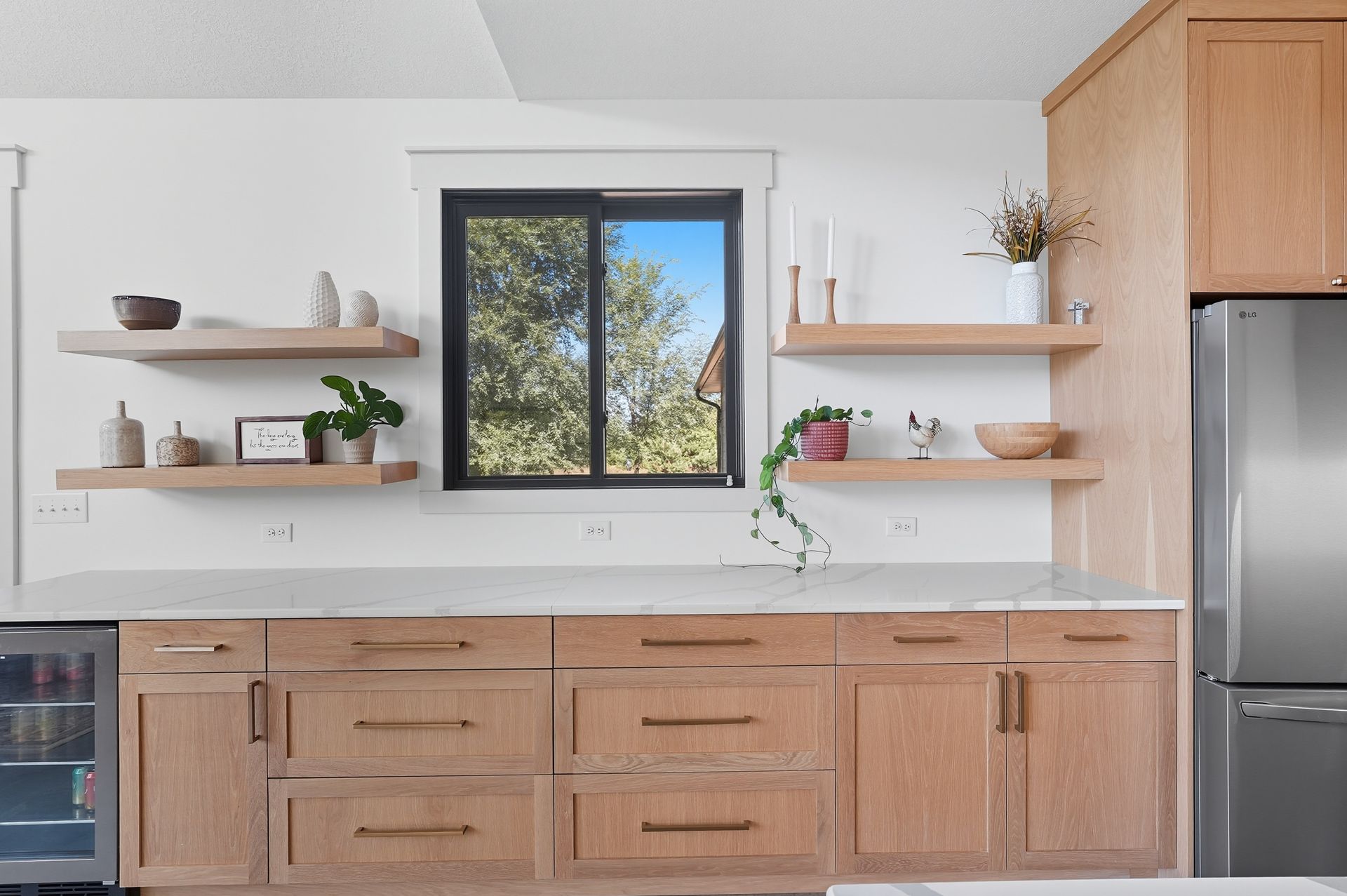 White oak Luxe Collection kitchen cabinetry with natural wood finish, white countertops, and custom range hood in Oak Grove, Minnesota.