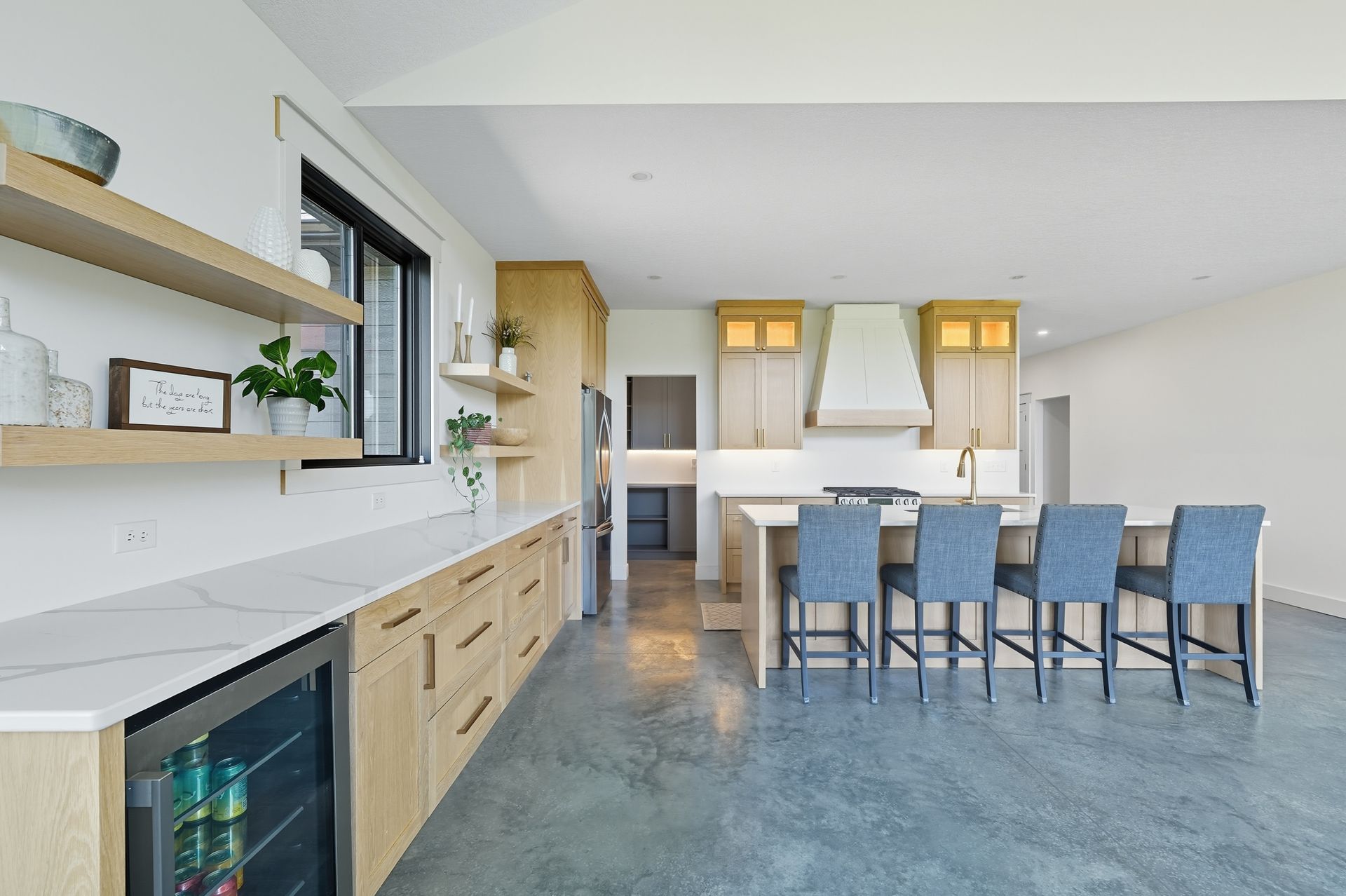 White oak Luxe Collection kitchen with large island, custom range hood, and natural wood cabinetry in Oak Grove, Minnesota.