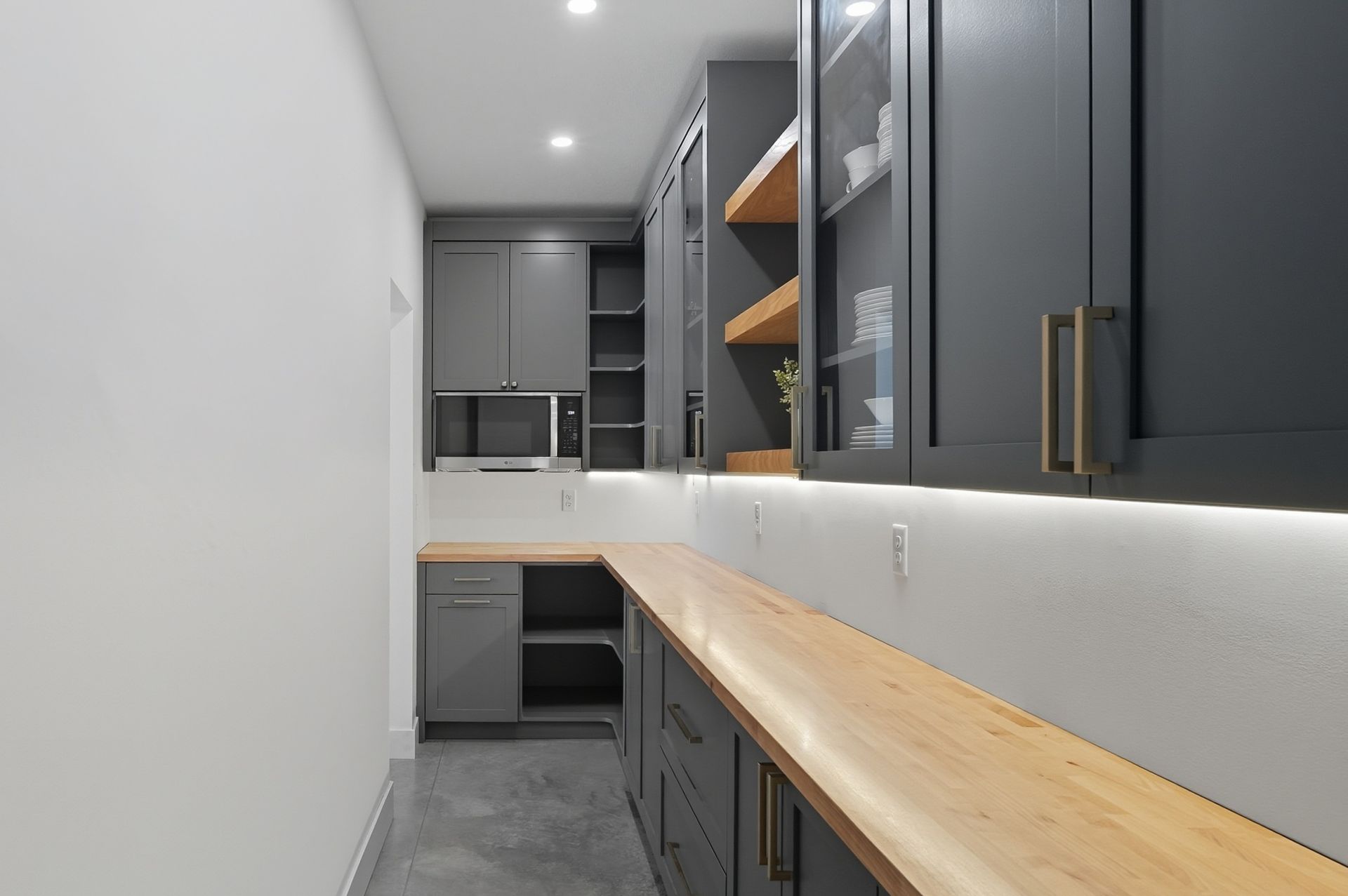 Custom gray pantry cabinets in Oak Grove, MN with wood countertops, open shelves, and built-in storage.