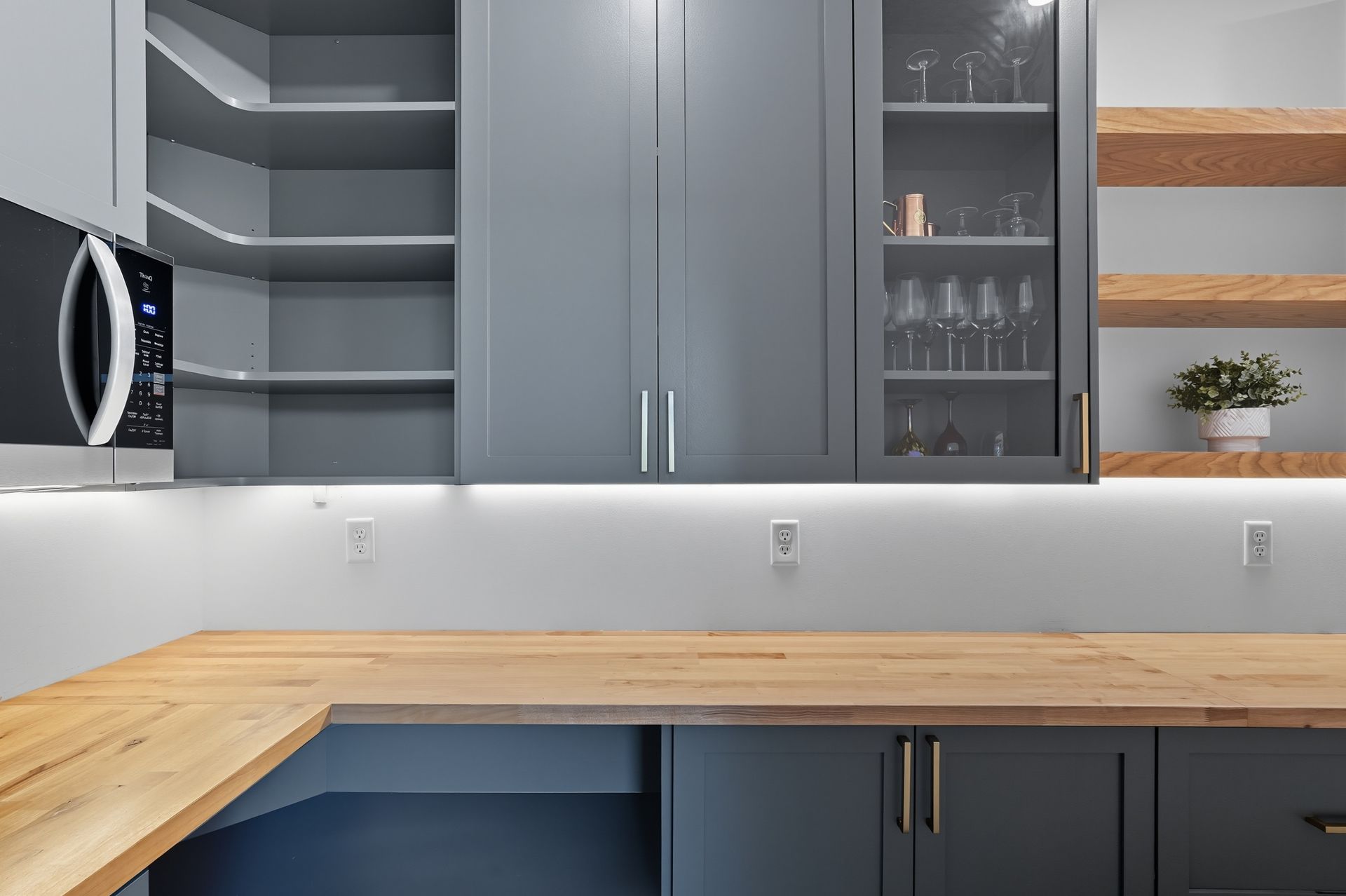 Oak Grove, MN pantry featuring gray custom cabinetry, corner storage, wood countertops, and open shelving.