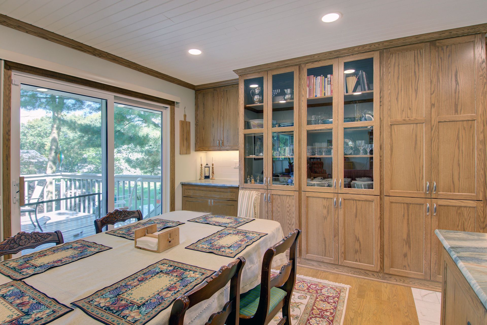 Custom oak kitchen cabinetry with glass-front display cabinets and built-in storage.