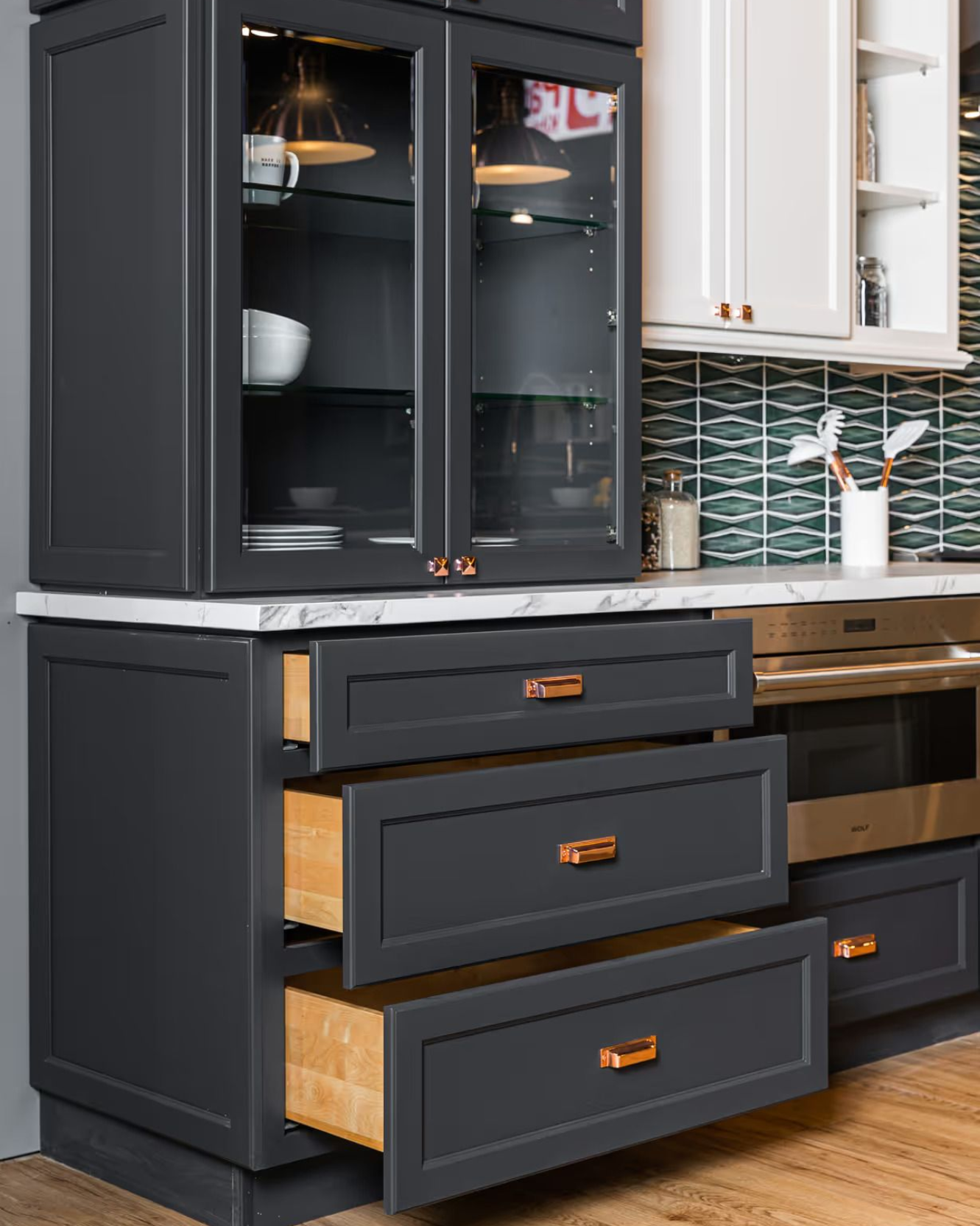 Dark semi-custom Summit cabinetry with glass doors and open storage drawers