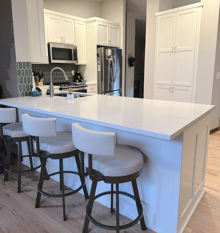 White Casa Collection kitchen cabinetry with large island seating and floor-to-ceiling pantry storage.