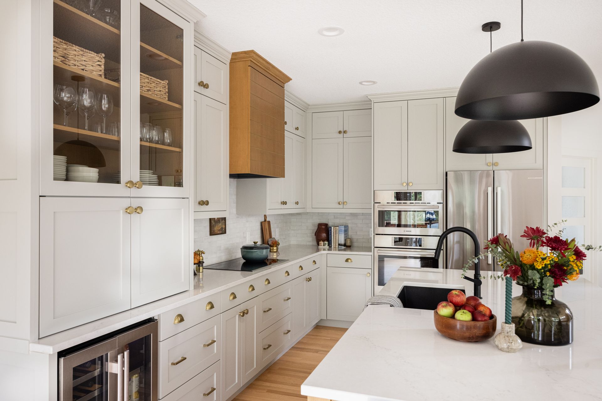 Custom white kitchen cabinetry with large island and natural wood accents in Woodbury, Minnesota.