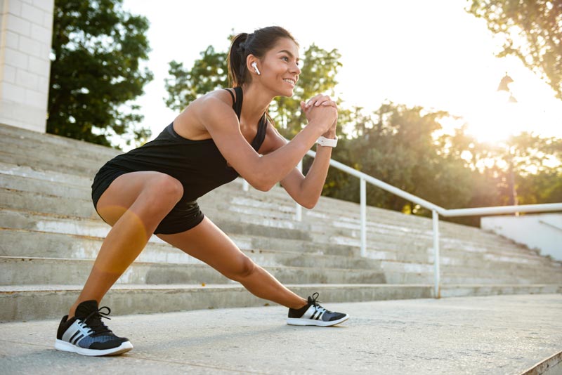 A woman is doing squats on a set of stairs.