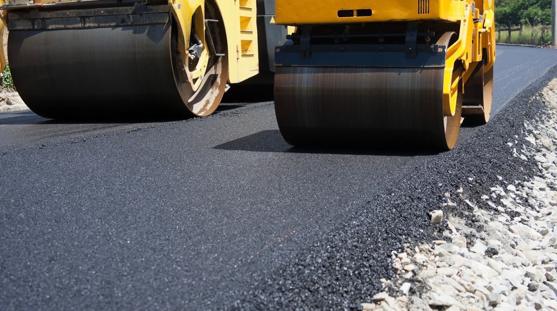 Road roller compacting fresh asphalt on a road surface