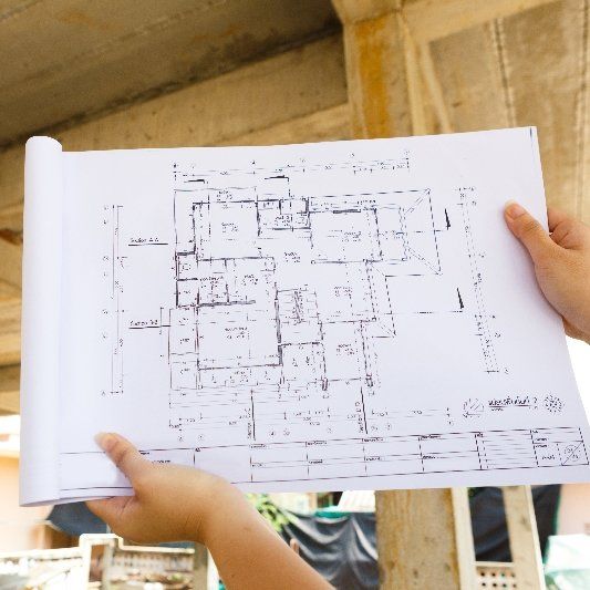 Person holding blueprints — Honolulu, HI — DRAFTECHi LLC