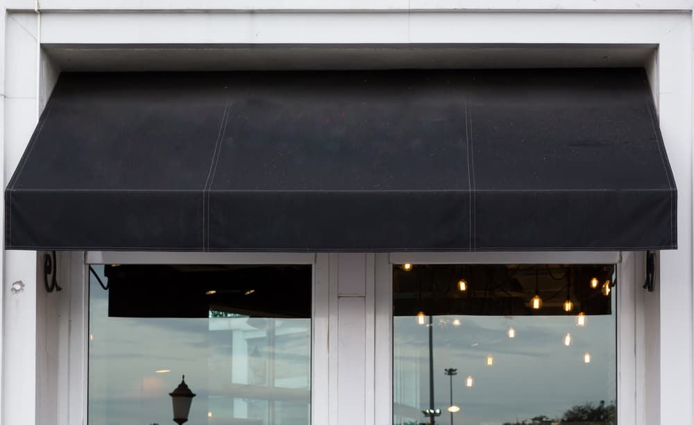 A Black Awning On A Building — Southern Blinds & Awnings In Mittagong NSW