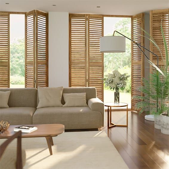 An Open Wooden Shutters In The Living Room With A Couch And A Table — Southern Blinds & Awnings In Balaclava NSW