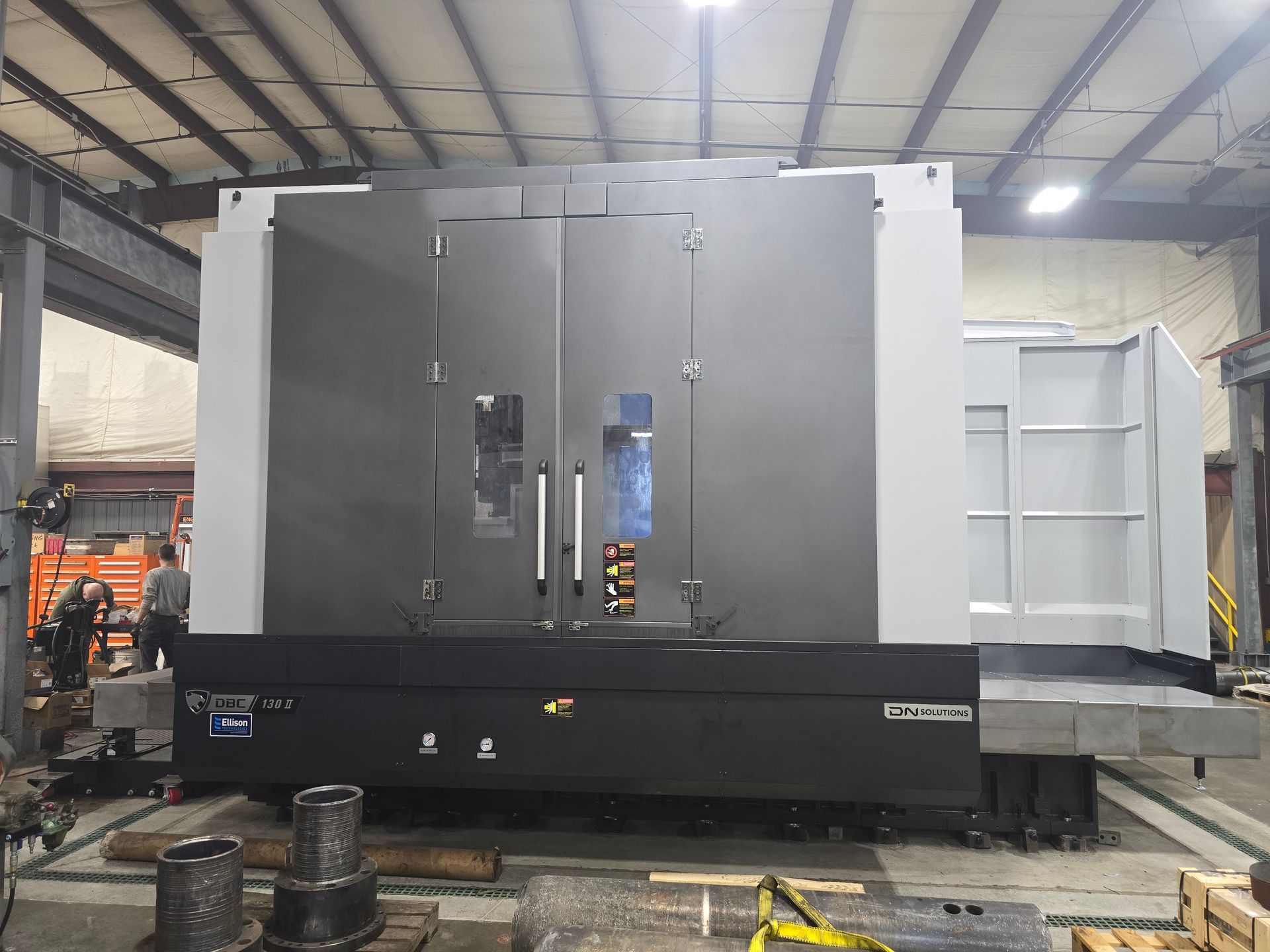 Large gray industrial machine in a workshop, with double front doors and a white side panel.