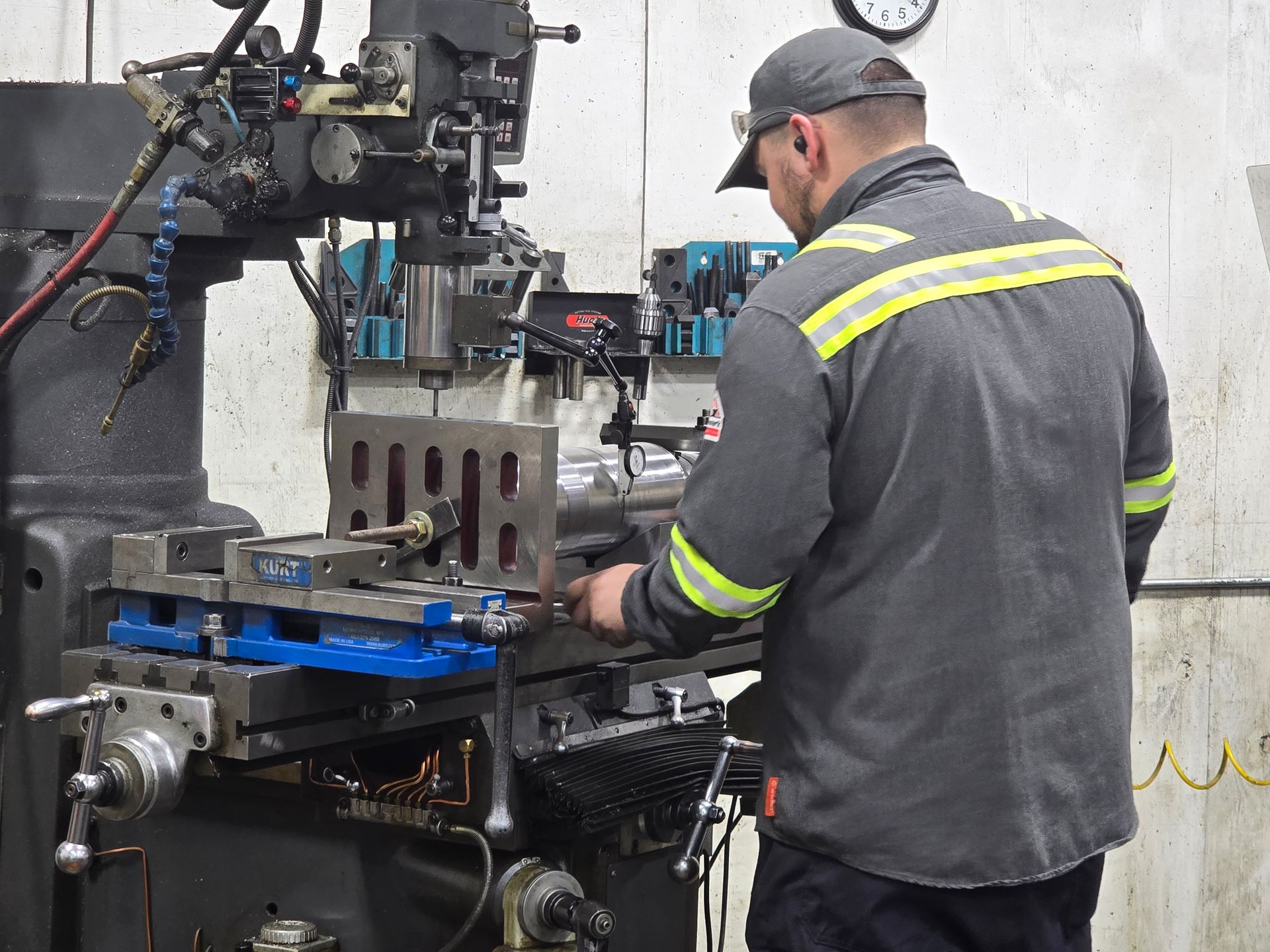 Worker operating a blue industrial machine in a factory workshop